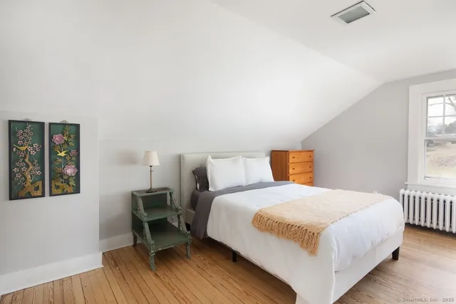 a bedroom with a bed a table and chair