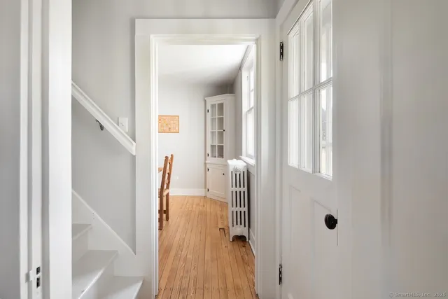 a view of a hallway with wooden floor and staircase