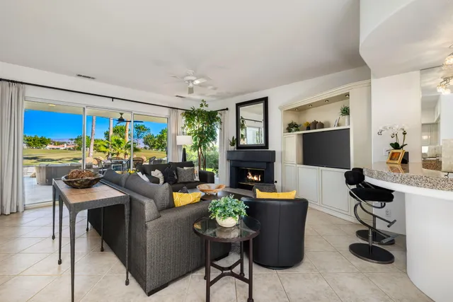 a living room with stainless steel appliances kitchen island granite countertop furniture and a flat screen tv