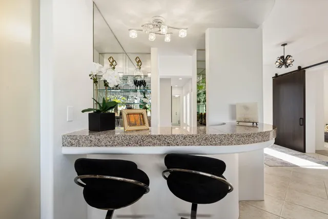 a kitchen with granite countertop a sink a stove and refrigerator