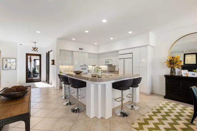 a kitchen with white cabinets and appliances