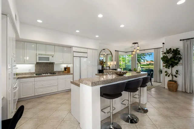 a kitchen with stainless steel appliances granite countertop a sink refrigerator and cabinets