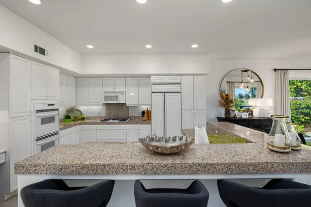 a kitchen with stainless steel appliances kitchen island granite countertop a sink and cabinets