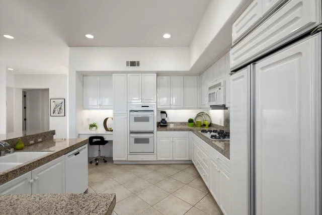 a view of a patio with table and chairs potted plants and large tree