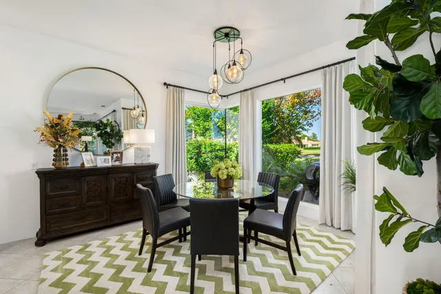 a view of a patio with couches table and chairs potted plants and palm tree