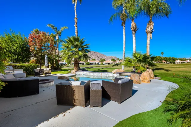 a view of a house with backyard and sitting area