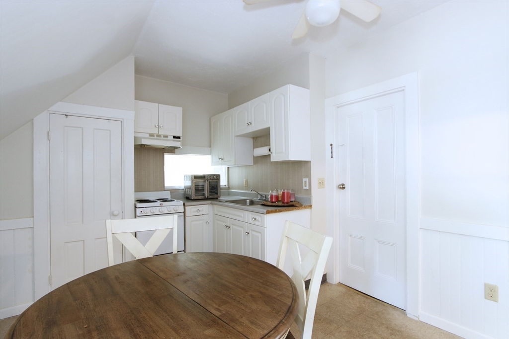 2 High Street Middleboro, MA 02346 - Photo 27 of 41 a kitchen with a sink a stove cabinets dining table and chairs
