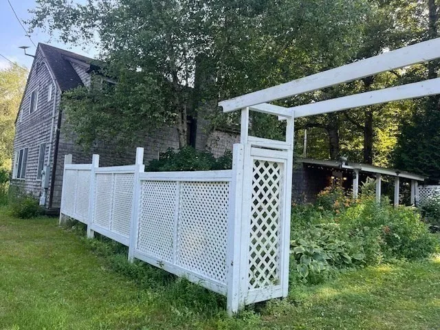 a view of a white house with a big yard and large trees