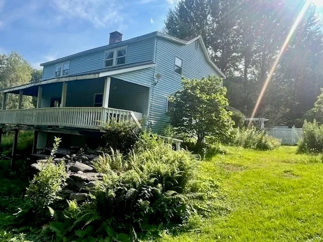 an empty room with wooden floor fireplace and windows