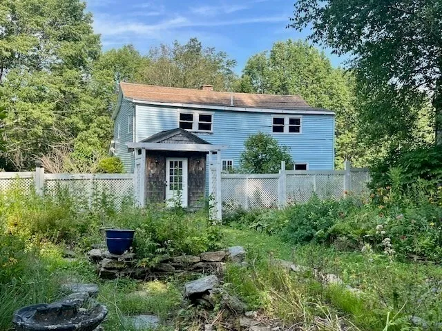 a view of a backyard with plants and brick wall