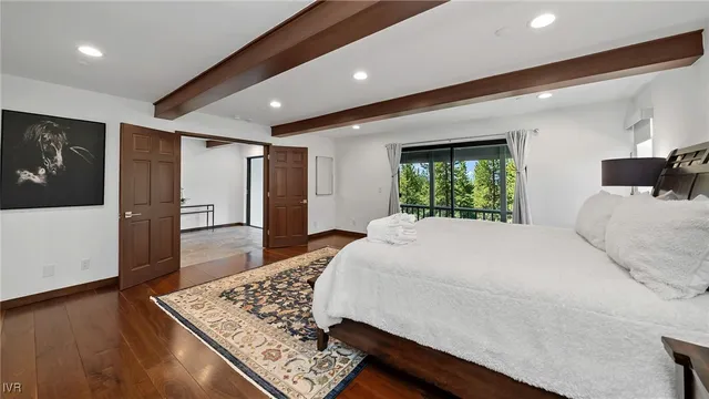 a large bedroom with a bed and wooden floor