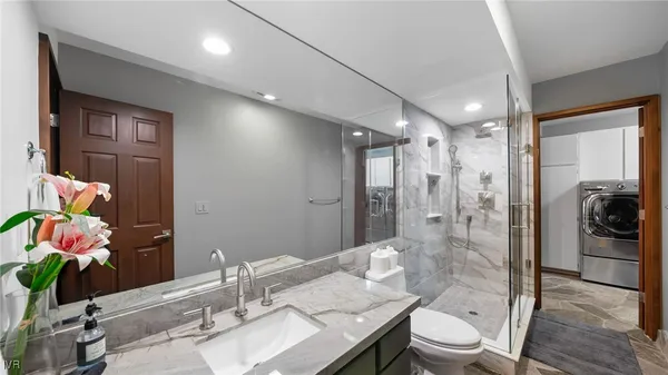 a bathroom with a sink vanity granite and toilet
