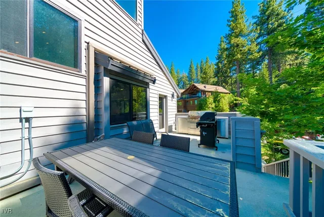 a view of a patio with table and chairs with wooden floor and fence
