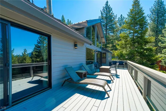a balcony with wooden floor and outdoor seating