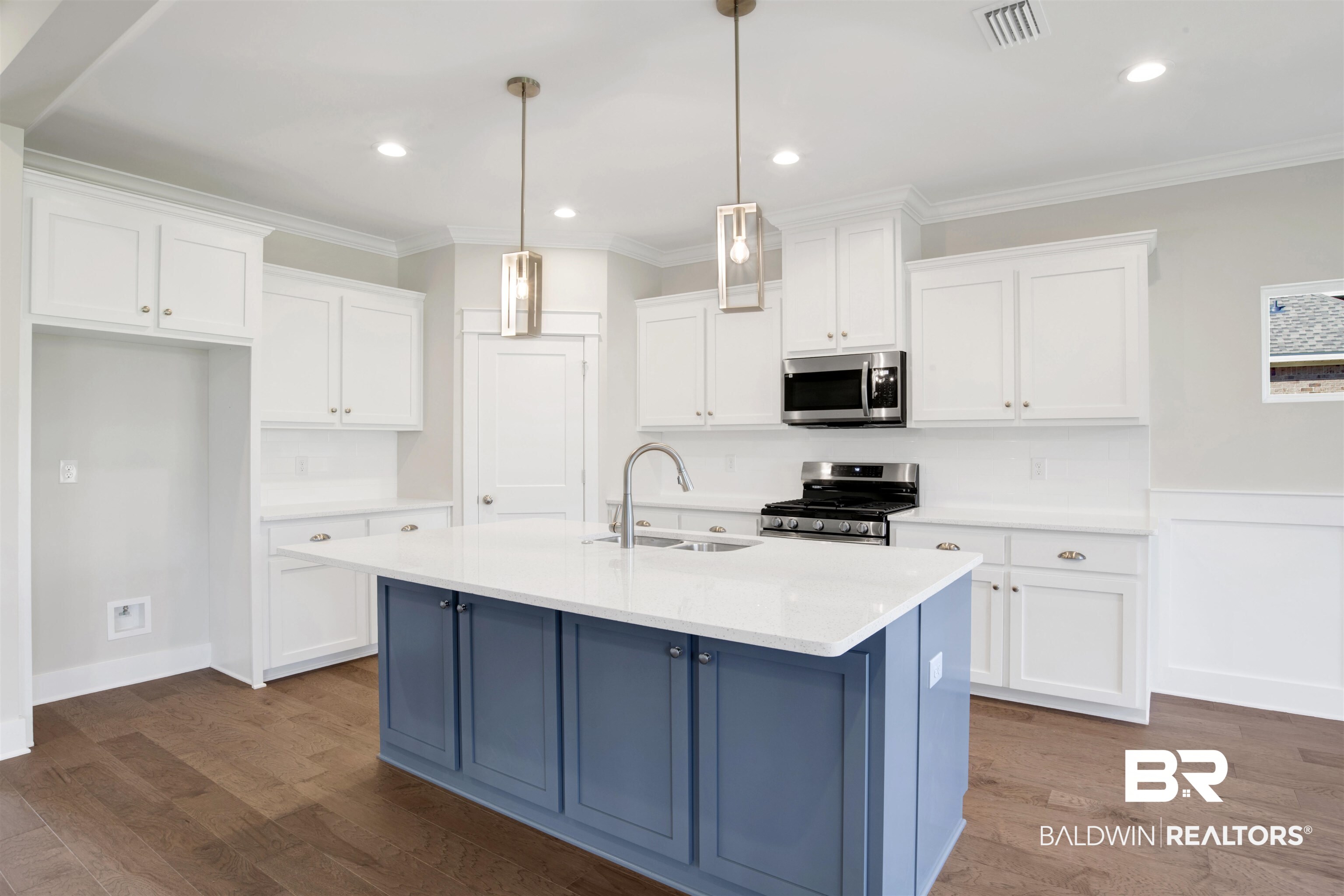 9687 Widgeon Court Daphne, AL 36526 - Photo 11 of 40 Kitchen with appliances with stainless steel finishes, sink, white cabinetry, hanging light fixtures, and an island with sink