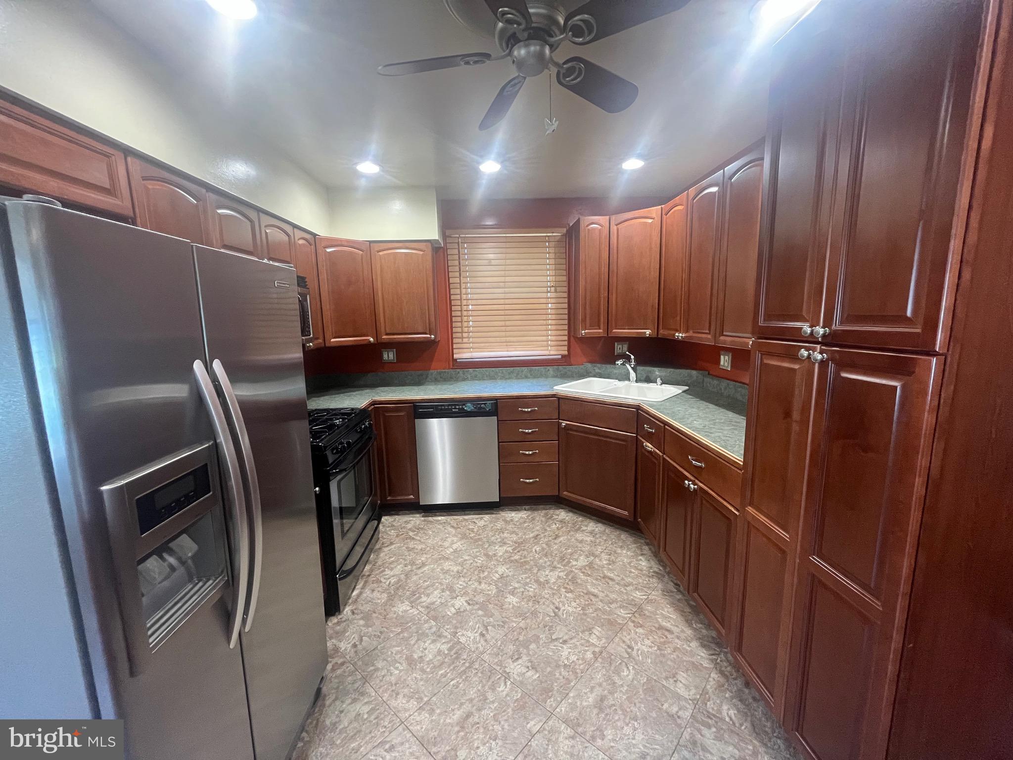 908 Homberg Avenue Baltimore, MD 21221 - Photo 19 of 31 a kitchen with stainless steel appliances granite countertop a sink refrigerator and cabinets
