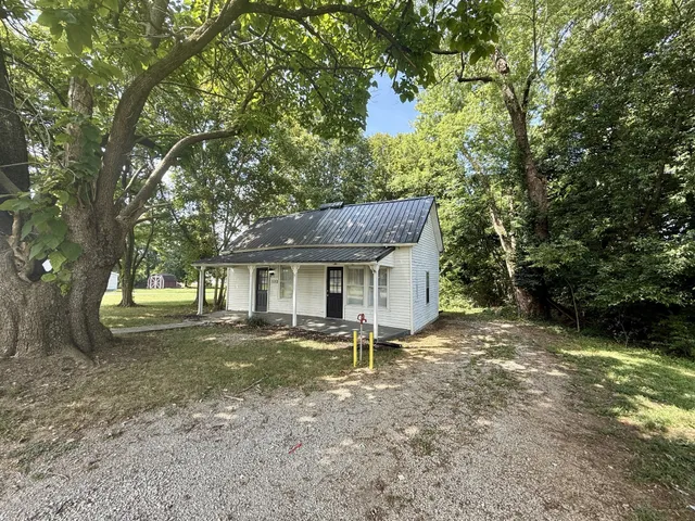 a backyard of a house with table and chairs