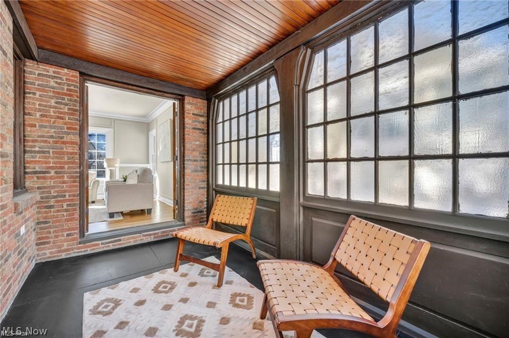 3145 Huntington Road Shaker Heights, OH 44120 - Photo 9 of 28 Enclosed sunroom featuring a brick wall, wood-finish ceiling, dark-framed multi-pane windows, and dark-toned flooring