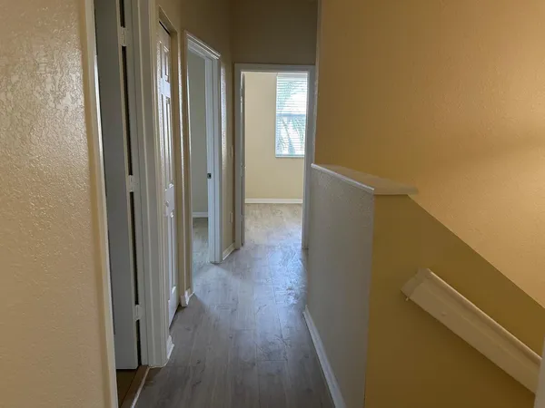 a view of a hallway with wooden floor