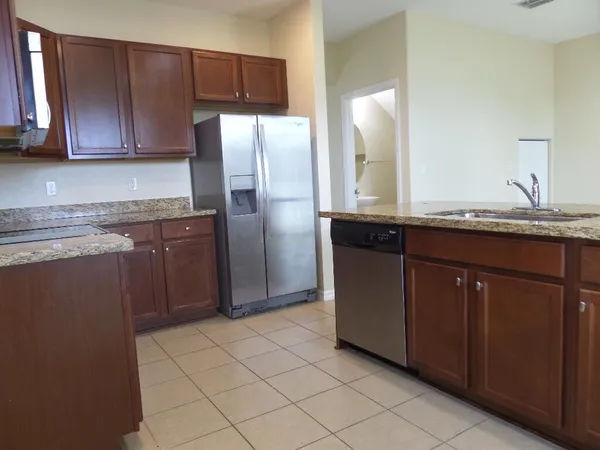 a kitchen with stainless steel appliances granite countertop a refrigerator and a sink