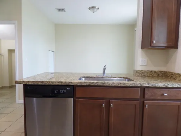 a kitchen with granite countertop a sink and cabinets