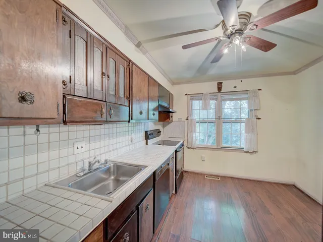 a kitchen with sink cabinets and wooden floor