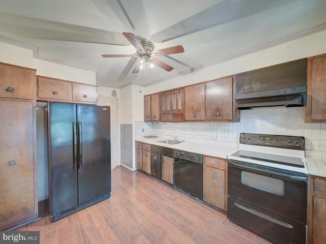 a kitchen with granite countertop stainless steel appliances and wooden floor
