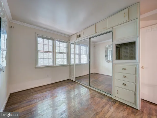 an empty room with mirror and windows