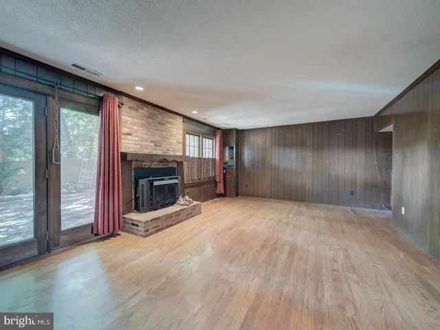 an empty room with floor to ceiling window and fireplace