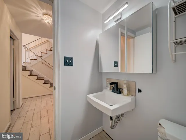 a bathroom with a sink a toilet and mirror