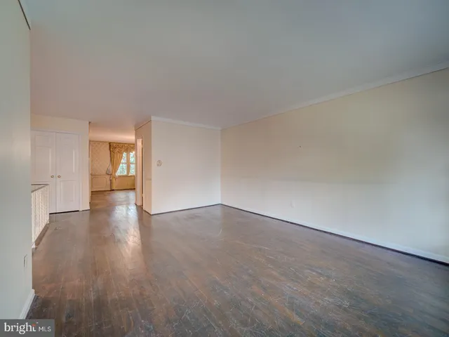 a view of an empty room and wooden floor and cabinets