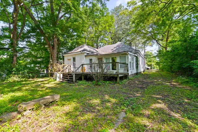 a white house that has a tree in front of it