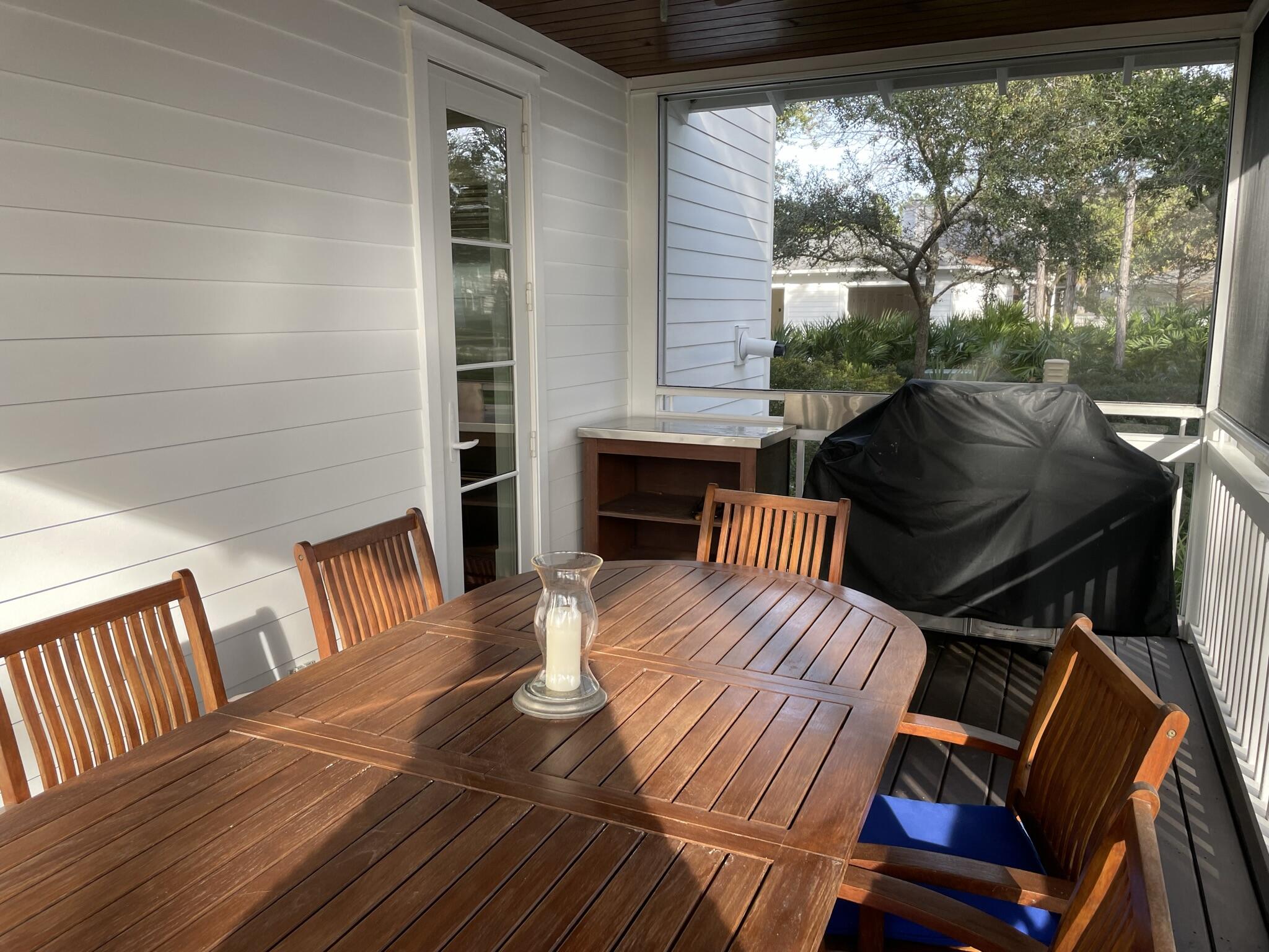 8119 Inspiration Drive, Unit B2 Miramar Beach, FL 32550 - Photo 20 of 44 a view of a patio with table and chairs with wooden floor and fence