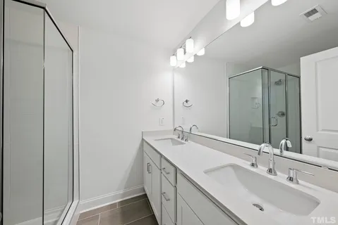 a bathroom with a double vanity sink and a mirror