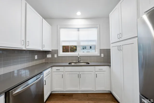 a kitchen with granite countertop white cabinets and white appliances