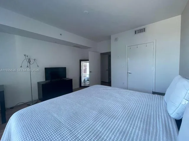 a bedroom with a bed and a television