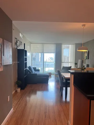 a living room with furniture and a wooden floor