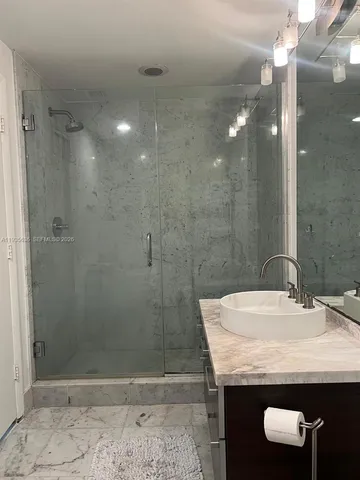 a bathroom with a granite countertop sink a toilet and shower