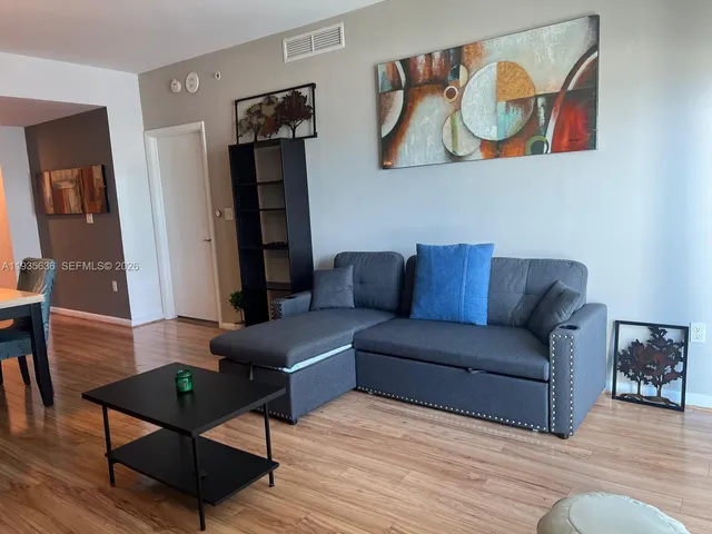 a living room with furniture and wooden floor