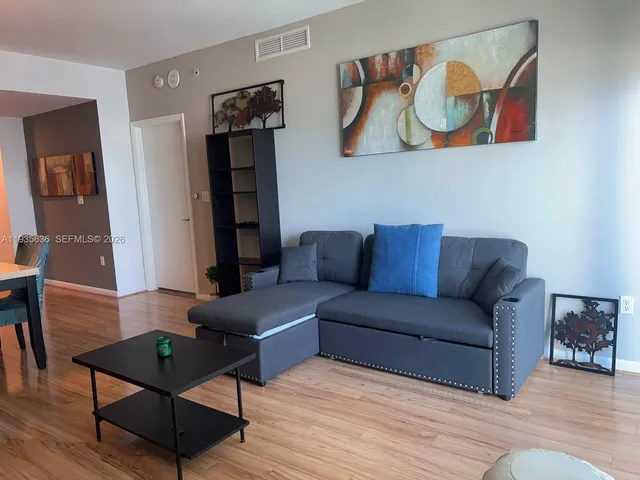 a living room with furniture and wooden floor