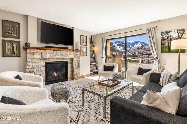 a living room with furniture a flat screen tv and a fireplace
