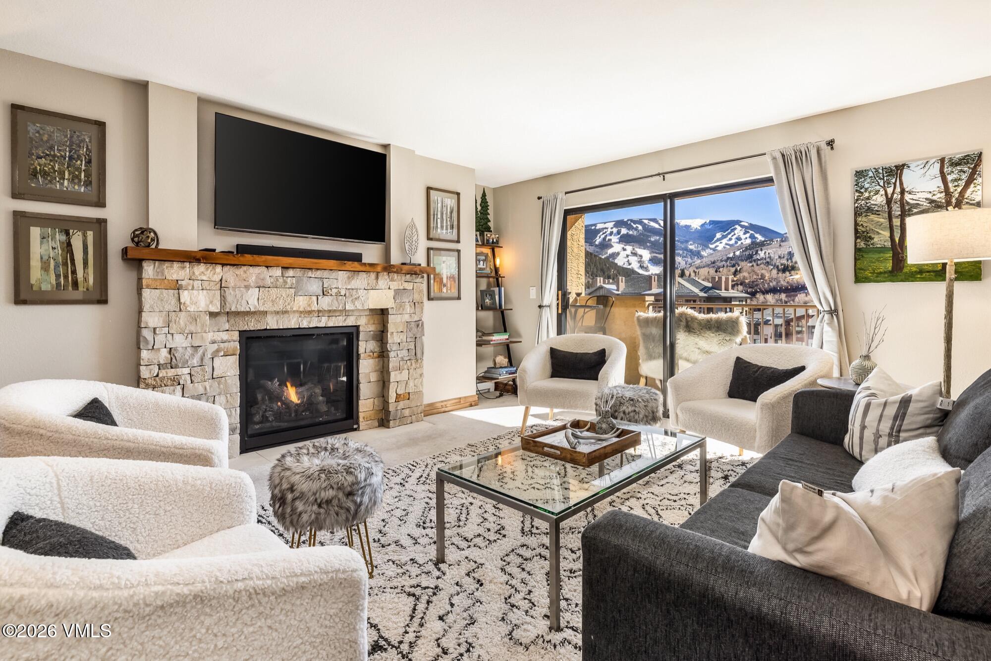 137 Benchmark Road, Unit 513 Avon, CO 81620 - Photo 1 of 31 a living room with furniture a flat screen tv and a fireplace