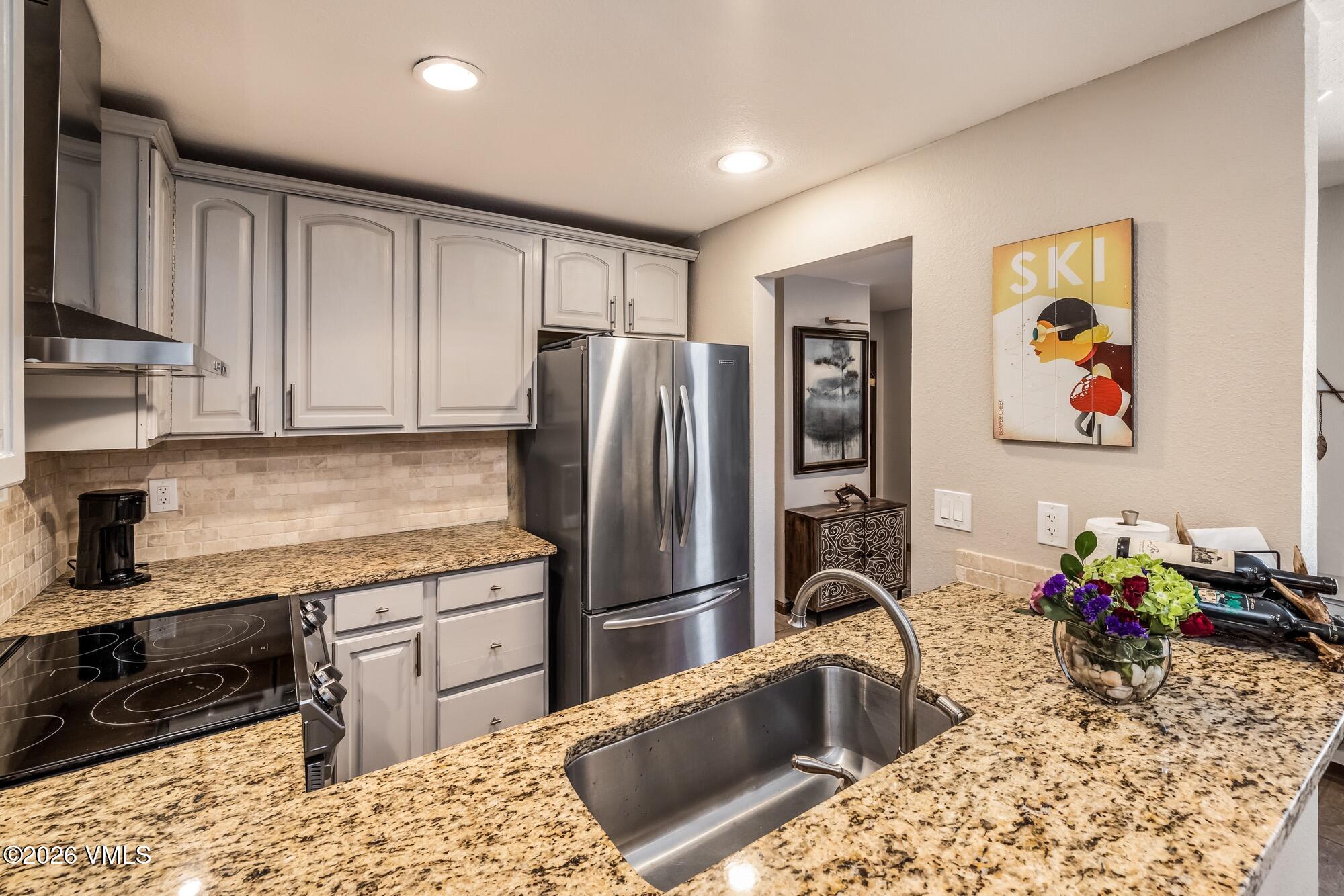 137 Benchmark Road, Unit 513 Avon, CO 81620 - Photo 11 of 31 a kitchen with granite countertop a refrigerator stove and sink