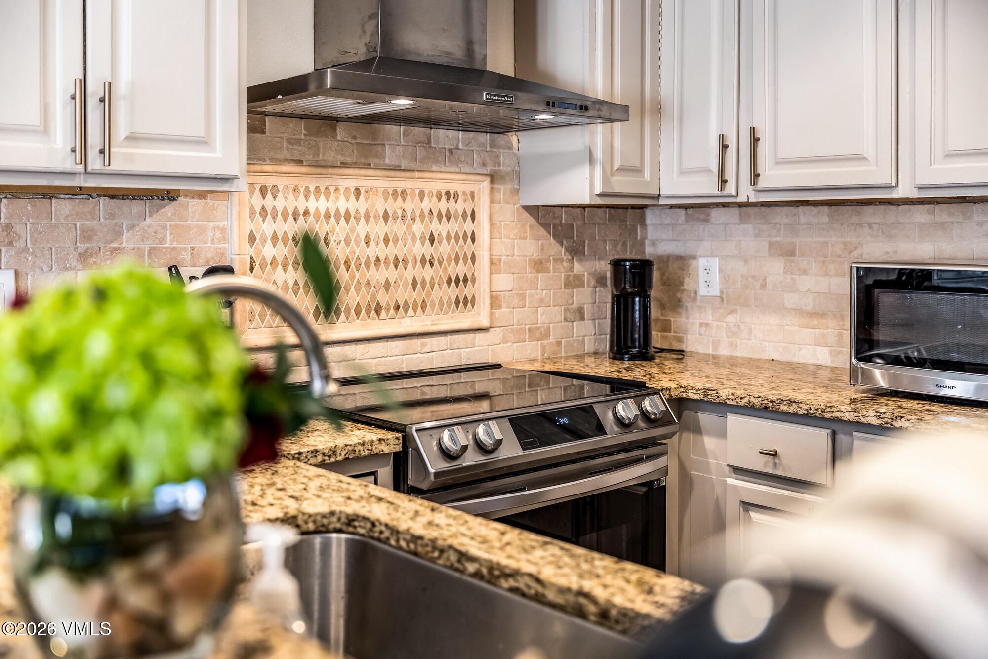 137 Benchmark Road, Unit 513 Avon, CO 81620 - Photo 12 of 31 a kitchen with a stove and a white cabinets