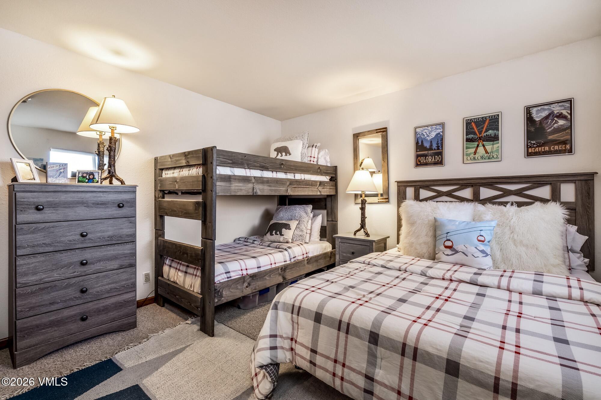 137 Benchmark Road, Unit 513 Avon, CO 81620 - Photo 24 of 31 a bedroom with a bed and a mirror