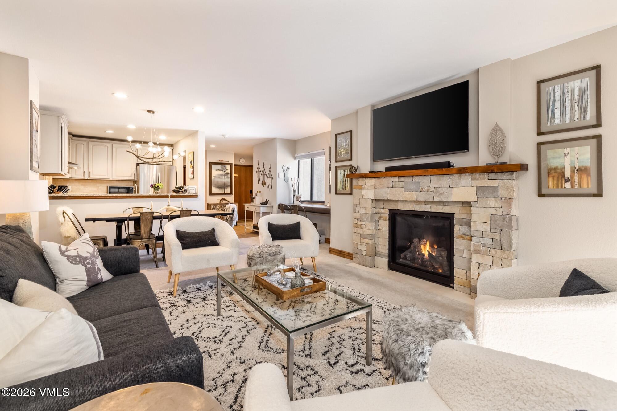 137 Benchmark Road, Unit 513 Avon, CO 81620 - Photo 5 of 31 a living room with furniture a flat screen tv and a fireplace