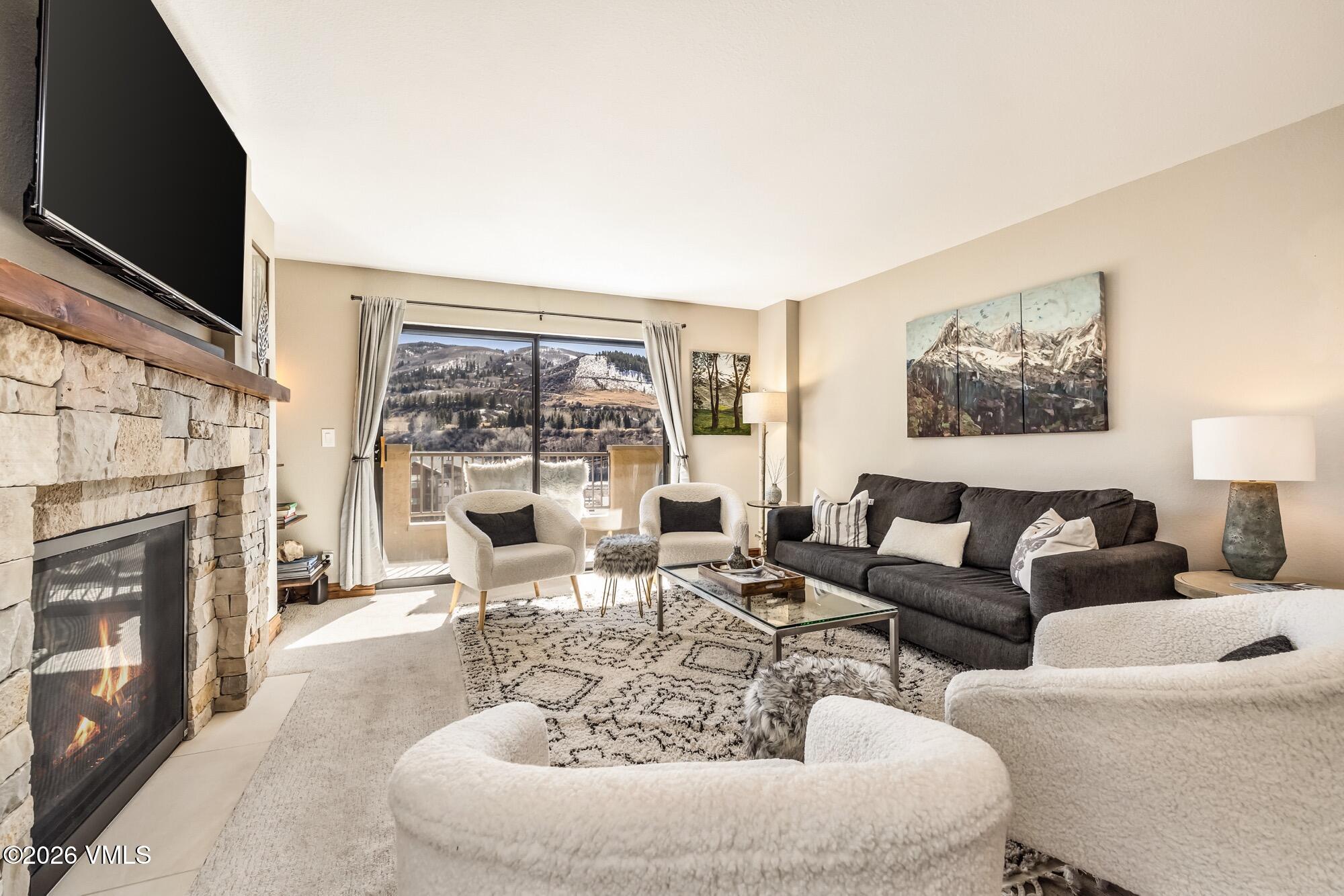 137 Benchmark Road, Unit 513 Avon, CO 81620 - Photo 9 of 31 a living room with furniture a fireplace and a flat screen tv