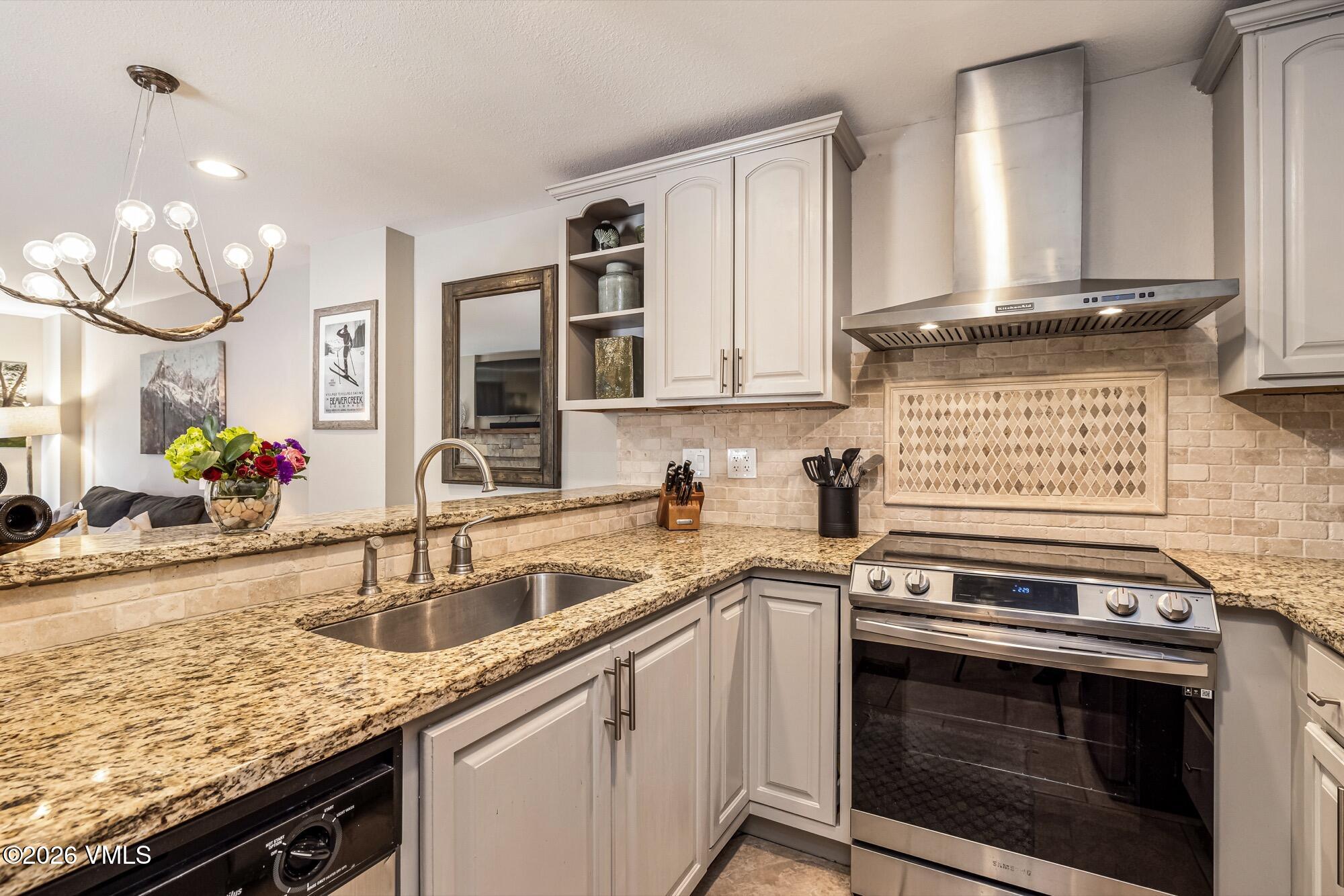 137 Benchmark Road, Unit 513 Avon, CO 81620 - Photo 10 of 31 a kitchen with granite countertop a sink stove and cabinets