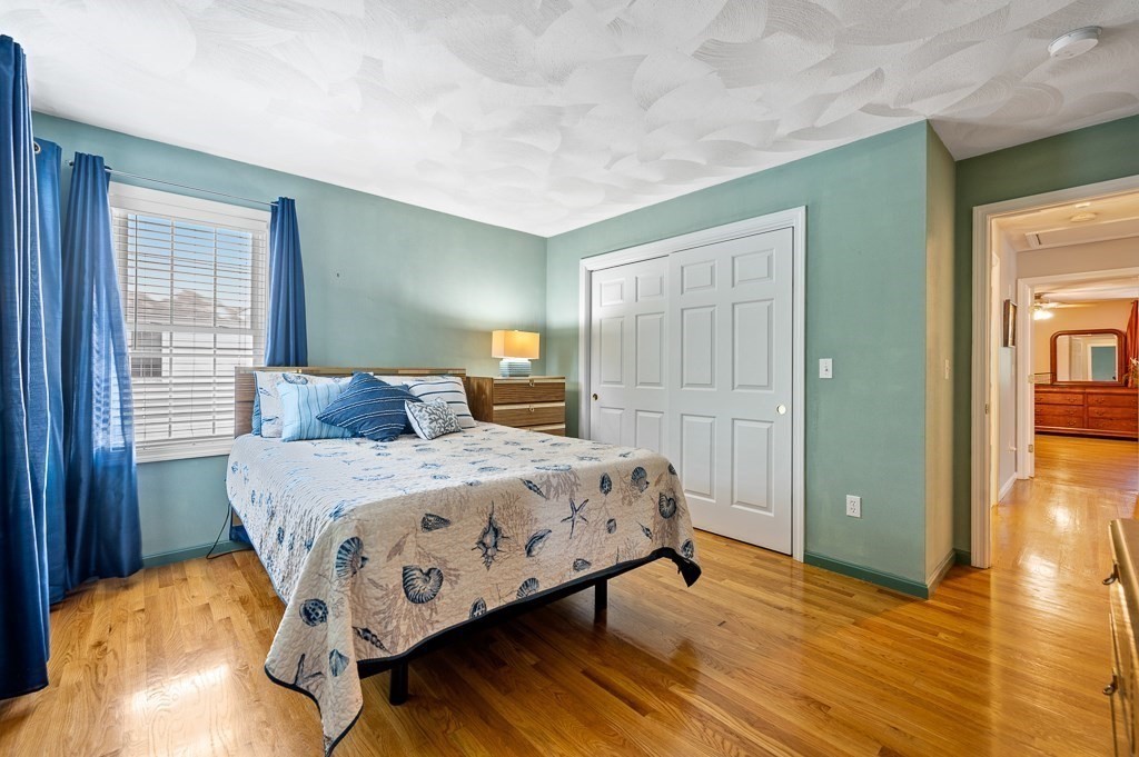 2 Gerry Drive, Unit 2 Hudson, MA 01749 - Photo 17 of 41 a bedroom with a bed and wooden floor
