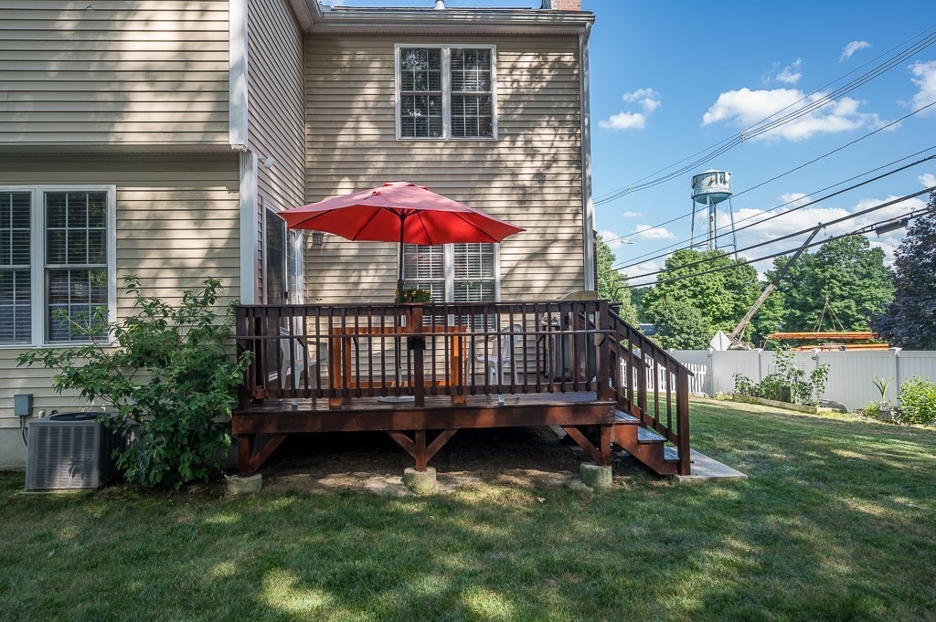 2 Gerry Drive, Unit 2 Hudson, MA 01749 - Photo 32 of 41 a view of a deck with a table and chairs under an umbrella
